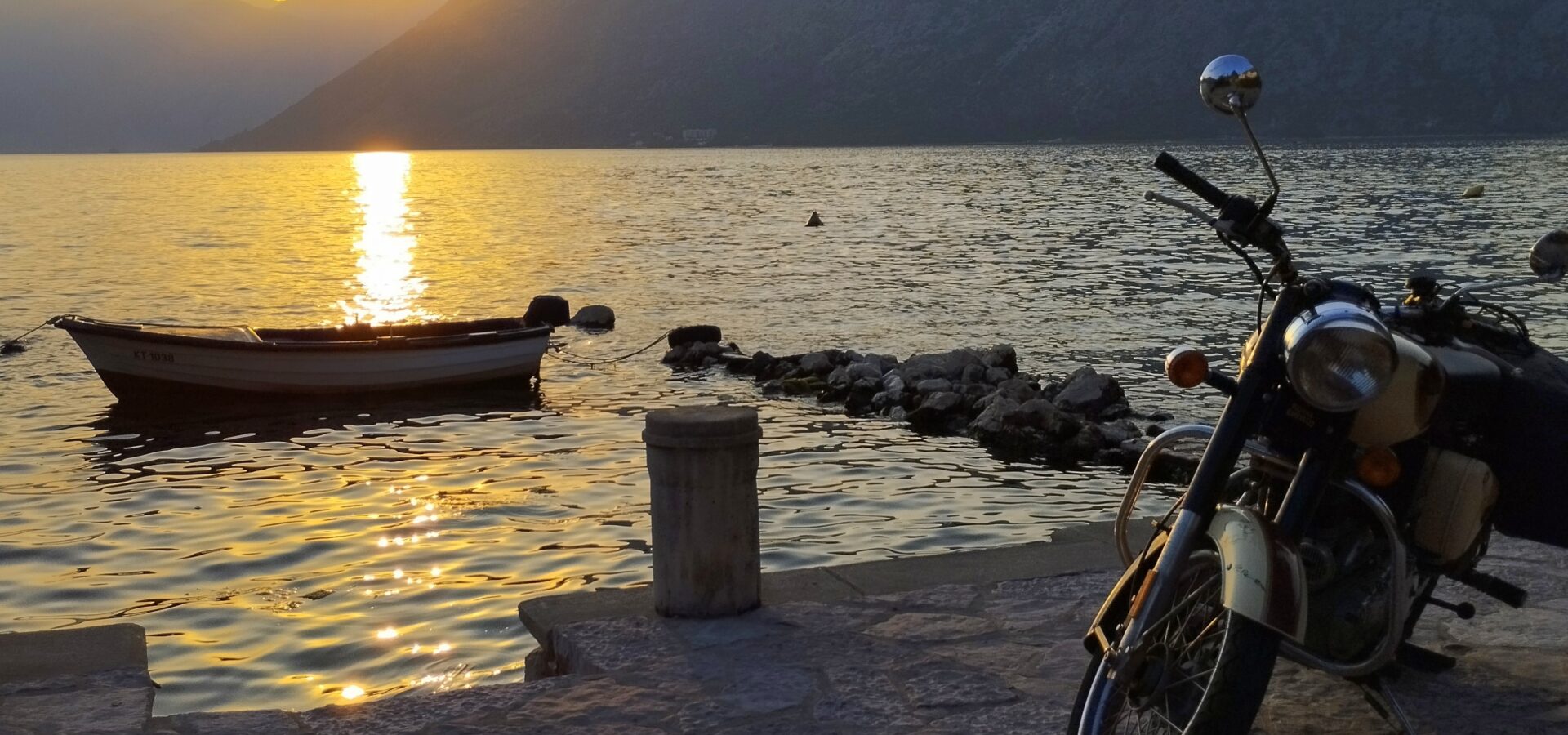 Royal Enfield am Ufer der Bucht von Kotor im Sonnenuntergang